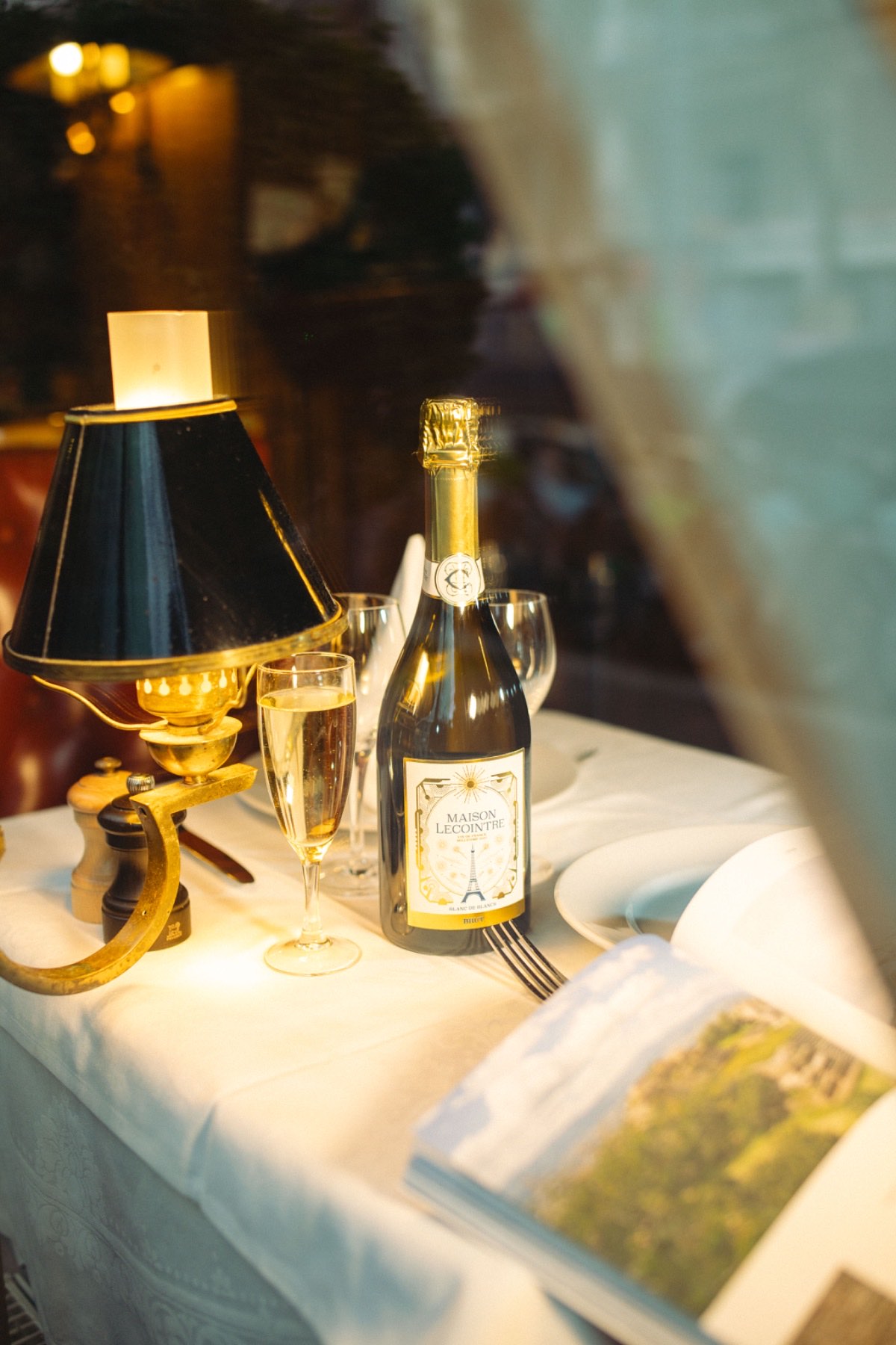 La cuvée sur une table dressée, derrière la vitrine d'un restaurant parisien